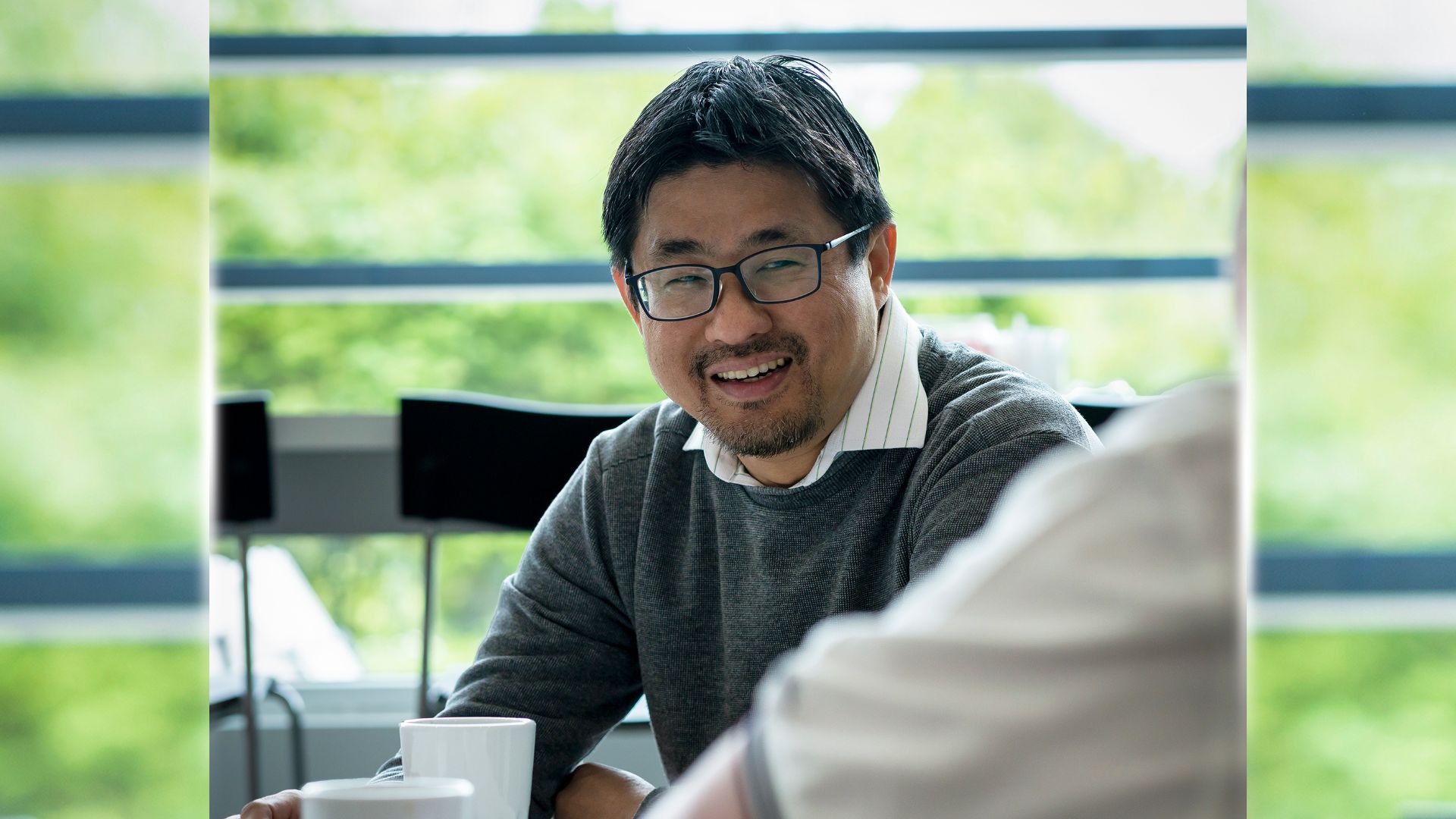 Cho Seng - Product Owner på Nor:disk - tar en kaffe med en kollega och ler. 