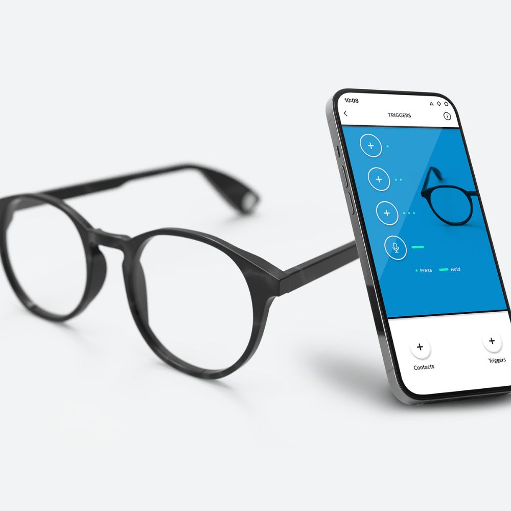 Xocchialis smarta glasögon bredvid en smartphone som visar appen som styr glasögonen.